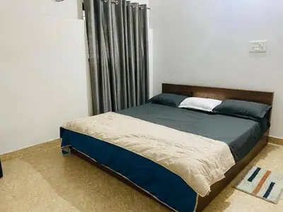 a bedroom with a large bed with blue and white sheets at Marayoor home stay in Marayoor