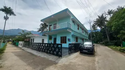 a blue house with a car parked in front of it at Marayoor home stay in Marayoor