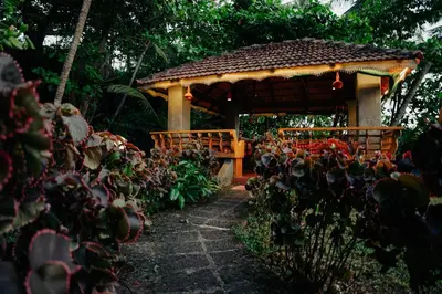 a wooden gazebo in the middle of a garden at Club 7 Beach Resort in Kannur