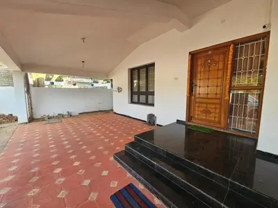 an empty room with stairs and a wooden door at SHI's Shenba 3BHk Villa Near Ganga Hospital Coimbatore in Coimbatore