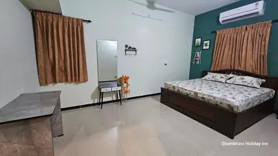 a bedroom with a bed and a table in it at SHI's Shenba 3BHk Villa Near Ganga Hospital Coimbatore in Coimbatore