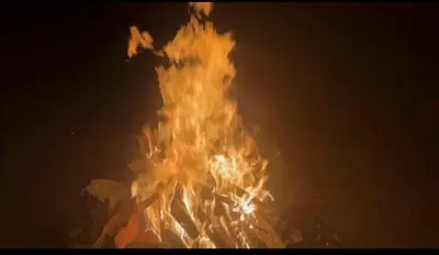 a large fire is burning in the dark at Mysticgreens Home Stay in Piriyāpatna