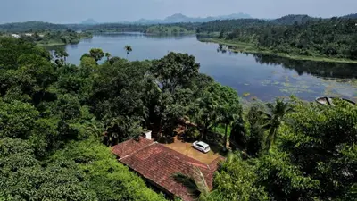 a car parked on top of a house next to a river at Wintervilla Cottages in Meppādi