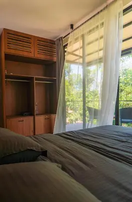 a bedroom with a bed and a large window at Trumpet Deck in Kutta