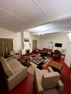 a living room with a couch and chairs and a tv at Villa Fair Winds, Sirukundra Estate in Vālpārai