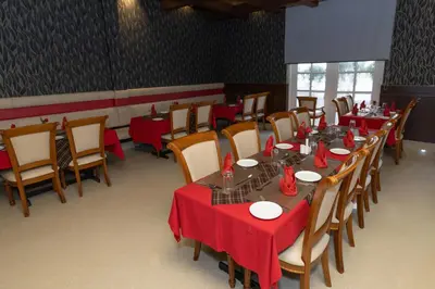 a dining room with tables and chairs with red table cloth at Hotel Luciya Palace in Trichūr