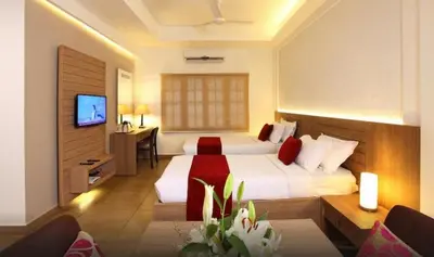a hotel room with a bed and a television at Hotel Luciya Palace in Trichūr