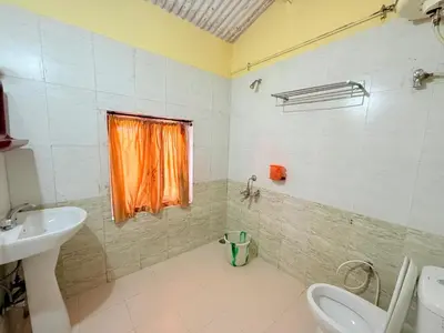 a bathroom with a sink and a toilet and a window at Ubuntu Retreat - Aaram & Mukaam in Ooty