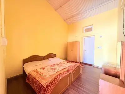a bedroom with a bed in a yellow room at Ubuntu Retreat - Aaram & Mukaam in Ooty