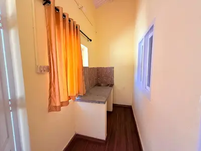 a bathroom with an orange curtain and a sink at Ubuntu Retreat - Aaram & Mukaam in Ooty