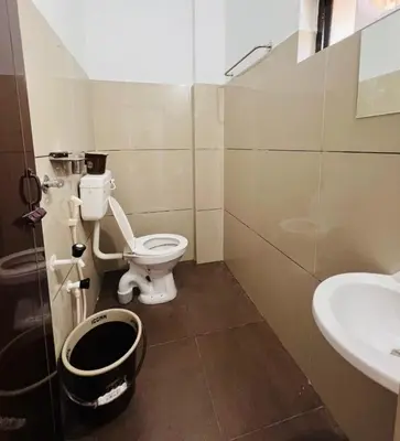 a bathroom with a toilet and a sink at SN RESiDENCY in Kozhikode