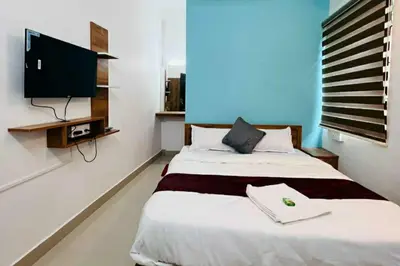 a bedroom with a large bed with a flat screen tv at SN RESiDENCY in Kozhikode