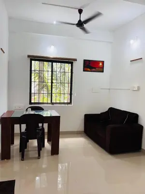 a living room with a table and a couch at SN RESiDENCY in Kozhikode