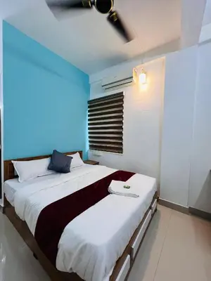 a bedroom with two beds and a ceiling fan at SN RESiDENCY in Kozhikode