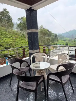 a table and chairs on a balcony with a view at eagle resort in Ketti