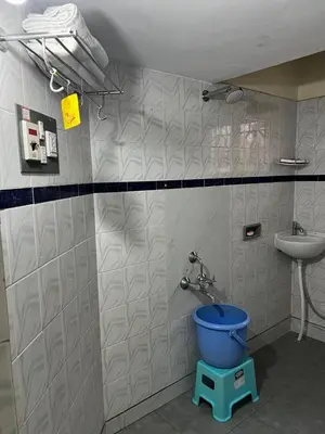 a bathroom with a toilet and a sink and a bucket at Akshaya - Charming 2BHK apartment with scenic view in Mysore