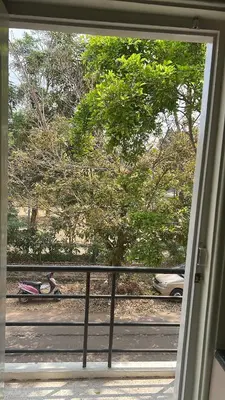 a view of a tree from a sliding glass door at Akshaya - Charming 2BHK apartment with scenic view in Mysore
