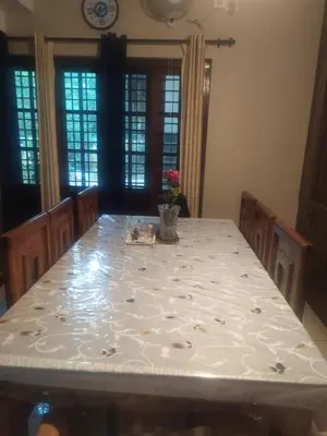 a dining room table with a white table cloth at Mayoorvihar home stay Sulthaan Bathery Wayanad Kerala in Sultan Bathery