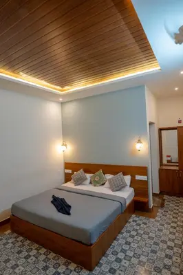 a bedroom with a bed with a wooden ceiling at Swastha Royal Resort Wayanad in Kaniyāmbetta