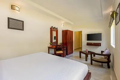 a bedroom with a bed and a desk and a television at Mango Hill Coimbatore-Near Isha Yoga in Alāndurai