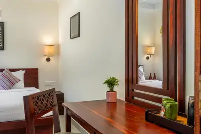 a bedroom with a table and a mirror at Mango Hill Coimbatore-Near Isha Yoga in Alāndurai