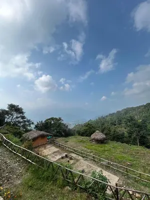 a field with huts on a hill with a sky at Nomadcasa Rooms in Kanthalloor