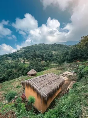 a small hut on a hill with a mountain at Nomadcasa Rooms in Kanthalloor