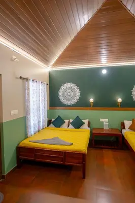 a bedroom with a yellow bed and a green wall at Swastha Heritage Homestays Wayanad in Kaniyāmbetta