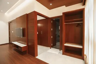 a walk in closet with wooden cabinets and a tv at Hotel Lakshmi Towers in Kāngayam