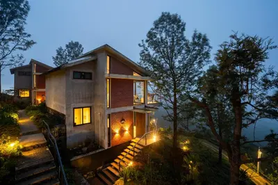 a house in the woods at night with lights at LohonoStays Amani Villa 11A in Coonoor