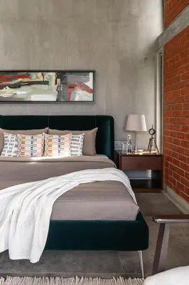 a bedroom with a bed and a brick wall at LohonoStays Amani Villa 11B in Coonoor