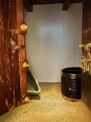 a corner of a room with a drum next to a door at Kappazha Tharavadu in Alwaye
