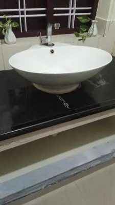 a white sink on a counter in a bathroom at Kappazha Tharavadu in Alwaye