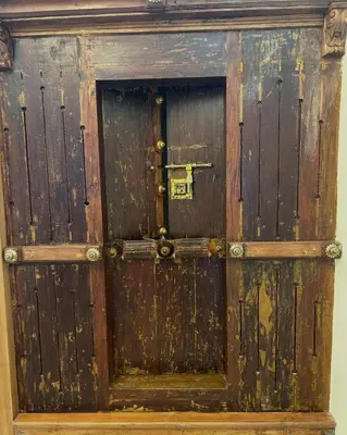 an old wooden door with a latch on it at Kappazha Tharavadu in Alwaye