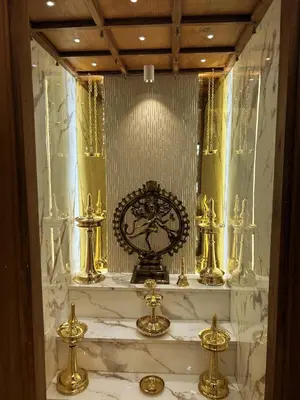 a bathroom with gold statutes and a clock on a shelf at Kappazha Tharavadu in Alwaye