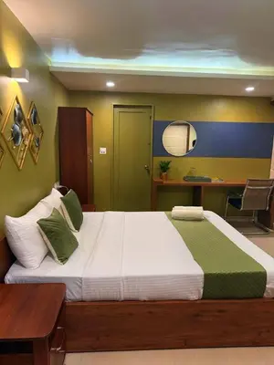 a bedroom with a large bed and a desk at Paradise Homestay in Alwaye