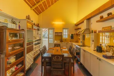 a large kitchen with a long wooden table in it at Bougainville, Wayanad in Kalpetta