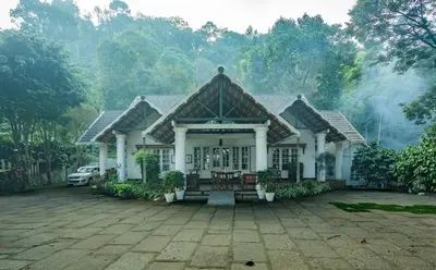 a house with a car parked in front of it at Bougainville, Wayanad in Kalpetta