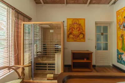 a bathroom with a glass shower with a deity on the wall at Bougainville, Wayanad in Kalpetta