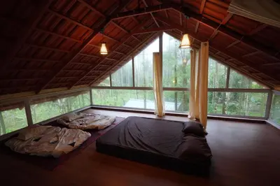 a bedroom with two beds in a room with windows at Areca Valley Farmstay in Agali