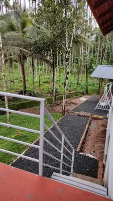 a white fence next to a yard with trees at Areca Valley Farmstay in Agali