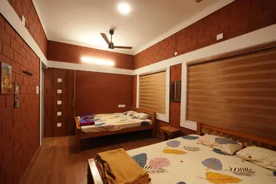 a bedroom with two beds and a window at Areca Valley Farmstay in Agali