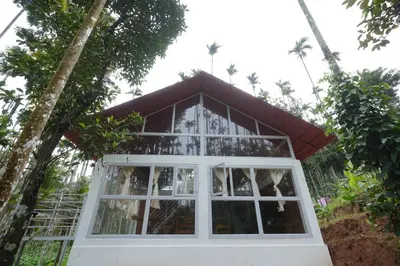 a small house with a window and trees at Areca Valley Farmstay in Agali