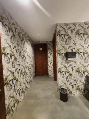 a hallway with a door and a wall with plants at VV's Lakshmi Inn in Thekkumkara