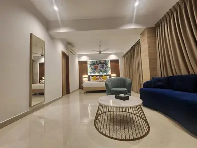 a living room with a blue couch and a table at VV's Lakshmi Inn in Thekkumkara