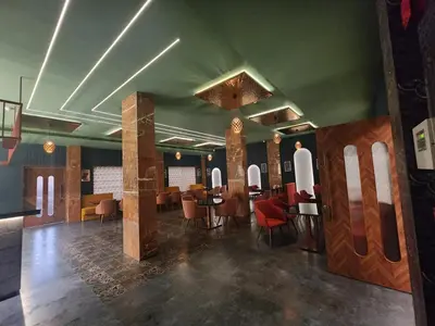 a restaurant with tables and chairs in a room at VV's Lakshmi Inn in Thekkumkara