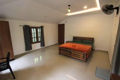 a bedroom with a bed and a window at Wayanad One in Wayanad