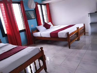 two beds in a room with red curtains at View Point Stay Coorg in Madikeri