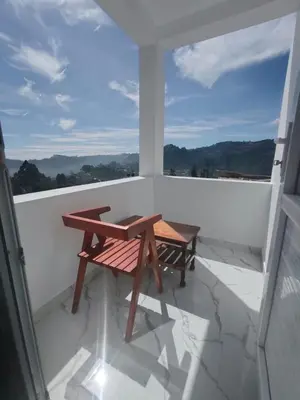 a wooden table and bench on a balcony at THE DEW stay Three bedroom villa in Kodaikānāl
