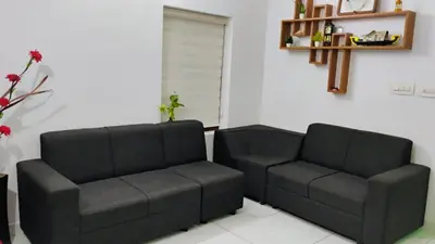 a living room with two chairs and a couch at Cozy Corner in Alwaye